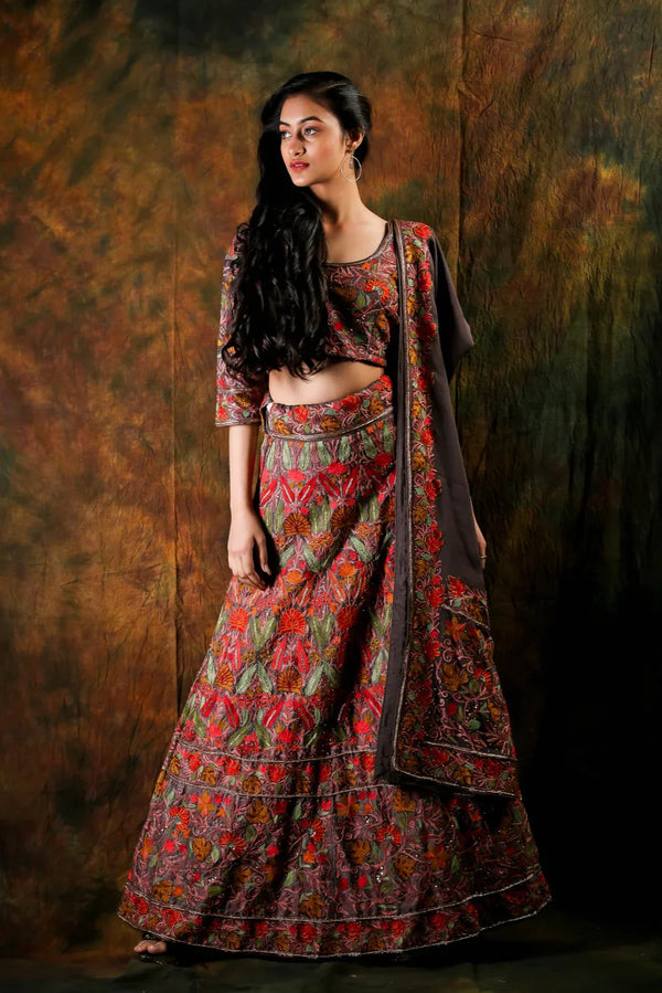 Woman wearing a traditional patterned outfit against a textured brown background
